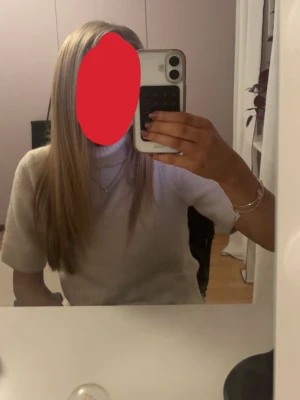 Vit stickad turtlenecktröja - Säljer en vit stickad turtlenecktröja med korta ärmar. Tröjan har en hög krage och är gjord i ett mjukt material som passar perfekt för lager-på-lager. Enkel och stilren design som är lätt att matcha med olika outfits. Väldigt liten i storlek så är som en S eller XS