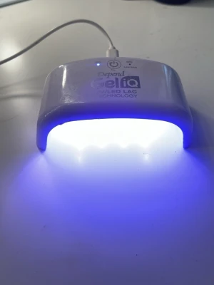 Depend Gel iQ UV/LED lampa - UV/LED-lampa från Depend Gel iQ, perfekt för att härda gelnagellack. Lampan är vit, kompakt och har en halvbågeformad design med knapp för timerfunktion. Tillverkad i plast och ansluts med USB-kabel. Passar för hemmabruk vid nagelvård. Nypris 259