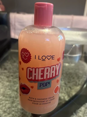I Love Cherry Pop duschkräm 500ml - Säljer en flaska I Love Cherry Pop Bath & Shower Cream på 500ml. Duschkrämen har en söt körsbärsdoft och kommer i en rosa plastflaska med färgglad etikett och rosa lock. Perfekt för dig som gillar fruktiga dofter i duschen.