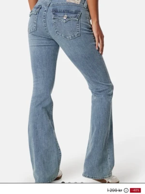 Blå bootcut jeans från True Religion - Snygga ljusblå bootcut jeans från True Religion Superfint skick och endast en liten röd fläck längst ner på ena benet modell Becca 