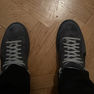 Oliver Cabell Mörkblå  - Snygga mörkblåa sneakers från Oliver cabell i ny skick och i mjuk mocka med vita snören och svart sula. Skorna har en diskret cirkeldetalj på sidan och blå hälkappa med präglad logga. Perfekta för dig som gillar stilrena och unika detaljer. Sköna till alla sorters av tillfällen.