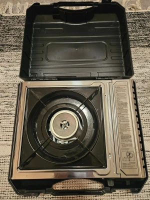 Portabel gasolkök i svart plastväska nytt - Smidigt portabelt gasolkök med en brännare, levereras i en robust svart plastväska. Perfekt för camping eller utflykter. Köket har metallgaller och tydliga på sidan. Enkel att bära med handtag på väskan.