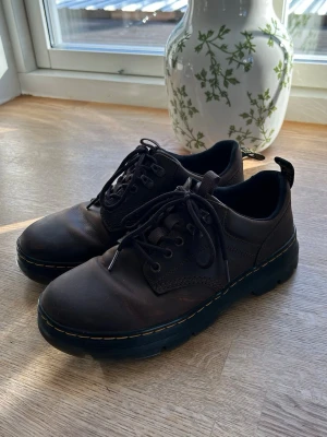Bruna Dr. Martens crazy horse reeder - Säljer ett par bruna Dr. Martens i läder med klassisk gul söm runt sulan. Skorna har snörning, robust yttersula och dragflik bak.