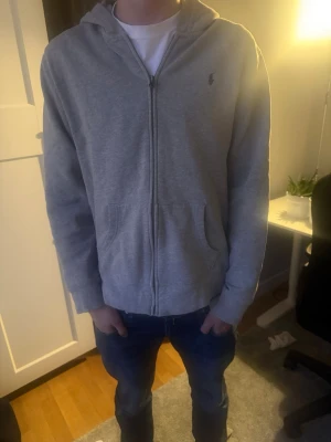 Grå zip hoodie från Polo Ralph Lauren - Snygg grå hoodie med dragkedja från Polo Ralph Lauren| nypris 1499kr|  säljer dessa pga att jag inte använder den längre|  modellen är i 178cm.