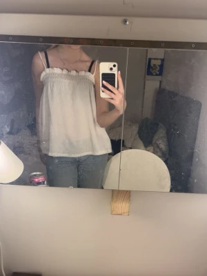 Vit ärmlös linnetopp med volang - Säljer en vit, linnetopp med volangdetalj längs halsen. Toppen är ny och använd en gång. Den är lite genomskinlig men har man vit bh så syns det inget. Jätte bra till våren och sommaren 🤍🤍🤍