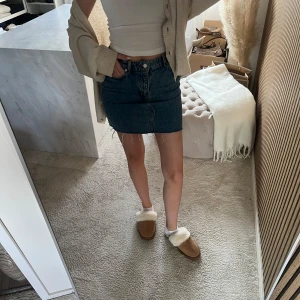 Mörkblå jeanskjol från h&m - Trendig mörkblå jeanskjol i kort modell med klassiska fickor fram och bak. Kjolen har en rak passform och synliga sömmar som ger en snygg detalj. Perfekt att matcha med en enkel topp eller stickad tröja.