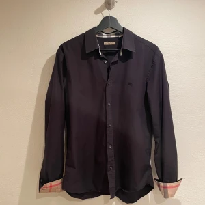 Svart skjorta från Burberry - Säljer nu min skitsnygga skjorta från Burberry!Skjortan är i nyskick och i storlek L men passar även M. Nypris ca 5000, mitt pris 999kr. Hör av er vid frågor. Mvh Luxery closet🙌