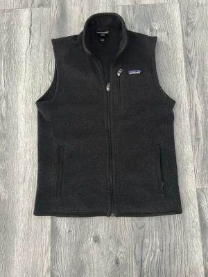 Svart fleeceväst från Patagonia - Klassisk svart fleeceväst från Patagonia, väldigt bra kvalitet och perfekt som lager på lager. Den sitter inprincip perfekt på mig och jag är 180cm. Hör av er vi frågor🙌