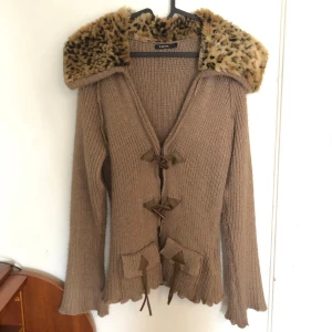 Kofta med leopardmönstrad päls - Snygg stickad kofta från b.young med stor krage i leopardmönstrad fuskpäls. Färgen är lite brun-beige. Något nopprig, går nog att ta bort. Varm och mysig och man ser garanterat cool ut😎— Skriv för frågor/fler bilder, PRIS KAN DISKUTERAS