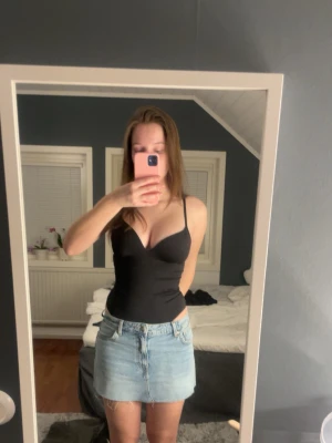 Svart body med tunna axelband - Säljer den jättepopulära slutsålda svarta bodyn från HM med tunna justerbara axelband och vadderade kupor. Snygg, figurnära passform som framhäver siluetten. Perfekt att styla med kjol eller jeans. Materialet känns mjukt och stretchigt mot huden. Aldrig använd bara testad. Passar S/M. Priset kan diskuteras💗💗