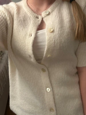 Stickad kofta  - Såå mysig o fin stickad kofta med korta ärmar från Gina Tricot. Skönt material o varm, passar bra till vardags. Knappt använd, jättebra skick o förekommer inga defekter. Skriv för fler frågor ❤️