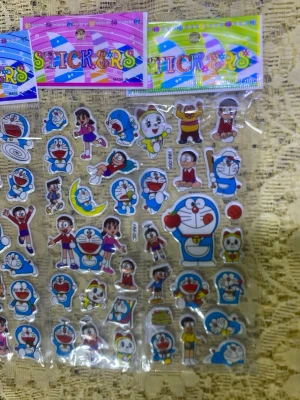 Doraemon klistermärken ark - Ett ark med färgglada Doraemon-klistermärken i olika former och storlekar. Motiven inkluderar Doraemon, Nobita och andra karaktärer från serien i olika poser och uttryck. Perfekt för att dekorera anteckningsböcker, laptops eller mobilskal.