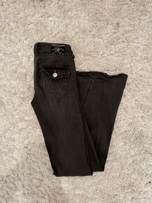 Gråa True Religion jeans - Snygga gråa true religion jeans som jag köpte på Nelly för kanske 1 år sen eller något men har aldrig använt dom, vet inte om dom finns kvar i denna modellen dock, dom är skit snygga och använda max 2 gånger 