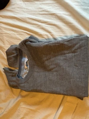 Grå basic tröja i bomull - En enkel och stilren grå tröja med rund halsringning. Tillverkad i mjukt bomullsmaterial och har långa ärmar. Perfekt att matcha med jeans eller för en clean look. Pris kan diskuteras! Storlek S passar xs