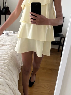 Ljusgul volangklänning med oneshoulder - Skit söt  ljusgul kortklänning med volanger!💕den har smala justerbara axelband ,därför passar den i många längder. Knappt några tecken på användning och säljer eftersom den inte andvänds