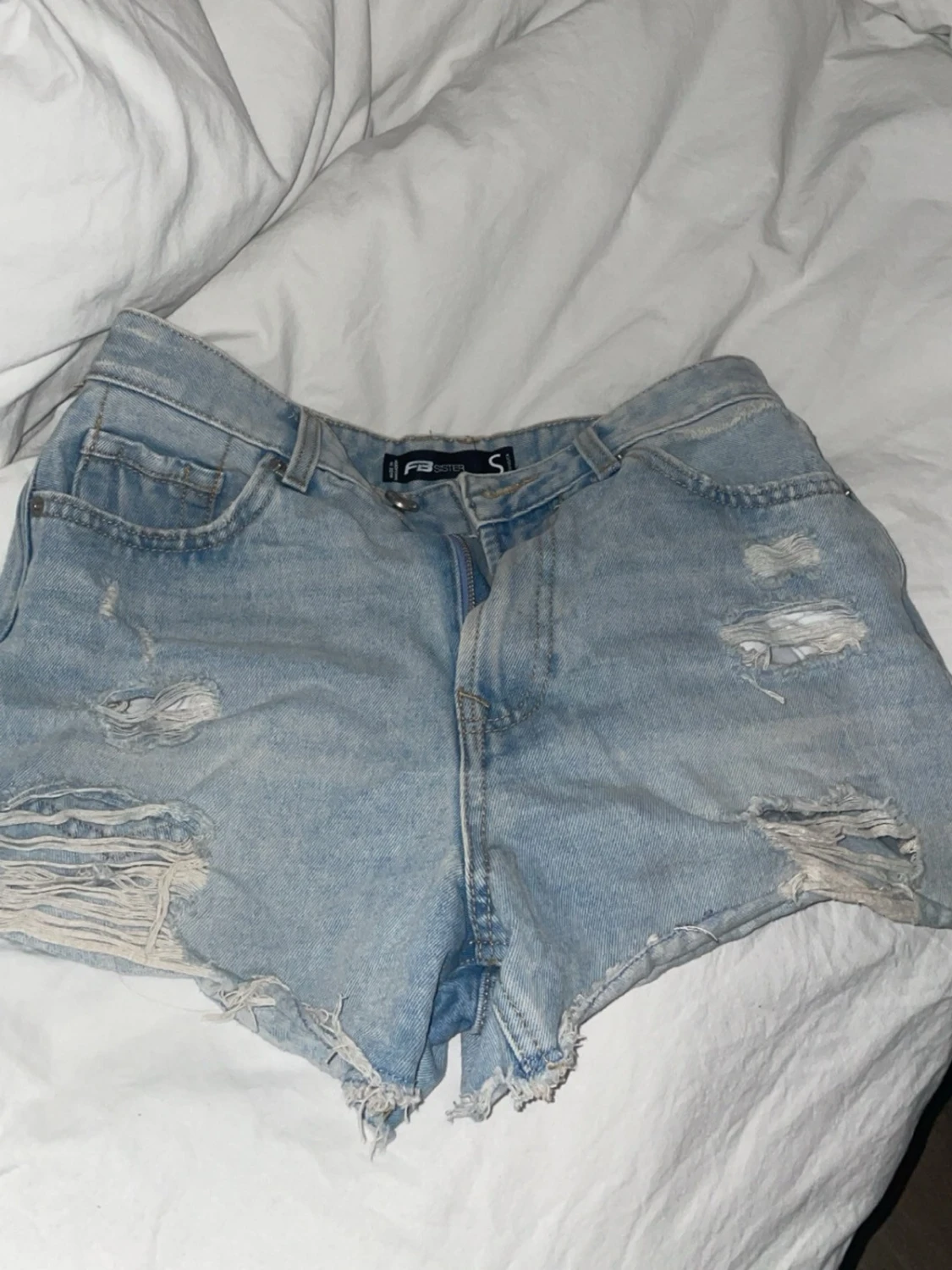 Ljusa blå jeansshorts med slitningar
