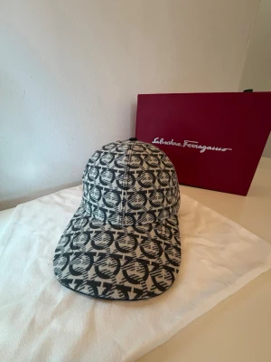  Ferragamo keps - Säljer en snygg keps från Salvatore Ferragamo perfekt nu när sommaren är runt hörnet. Kepsen kommer med box och dustbag. En mycket fin keps och perfekt för att matcha din outfit.