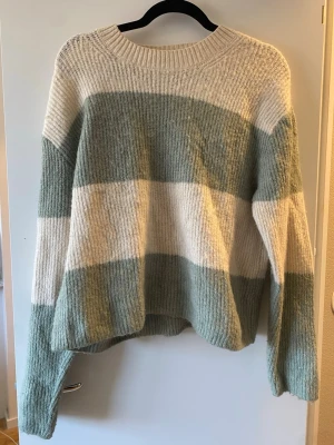 Randig stickad tröja från H&M - Mysig stickad tröja från H&M med breda ränder i ljusgrönt och vitt😍😍