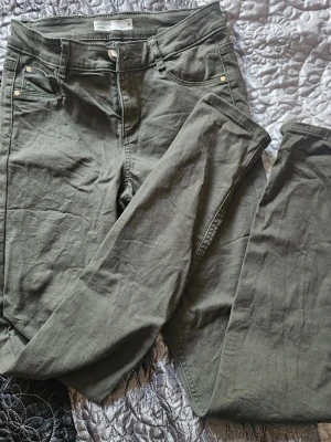 Olivgröna jeans från Cubus - Snygga olivgröna jeans från Cubus med klassisk femficksmodell och raka ben. Jeansen har knapp- och dragkedjestängning samt bälteshällor. Tillverkade i ett mjukt bomullsmaterial med lite stretch för extra komfort.