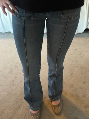 Blå bootcut jeans med sömmar - Snygga blå bootcut jeans med markerad söm framtill och klassiska fickor. Jeansen har en lätt utsvängd passform nertill och är tillverkade i denim. Perfekta för en avslappnad och trendig look.