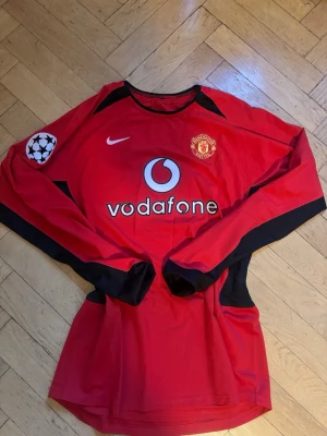 Manchester United tröja V. Nistelrooy - Röd långärmad Manchester United matchtröja med Champions League-märke på ärmen och Van Nistelrooy på ryggen. Large i storleken men passar lätt en Medium oxå. Använt tröjan en enda gång🙌
