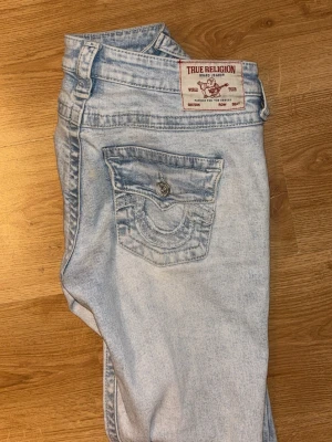 True religion jeans lågmidjade bootcutjeans - Mycket bra skick, knappt använda eftersom de är lite för stora för mig. Storlek 25 men lite större i storleken än de andra jag har i samma storlek. Väldigt fina detaljer på fickorna och i en ljusblå färg. Nypris 1299kr pris kan diskuteras.