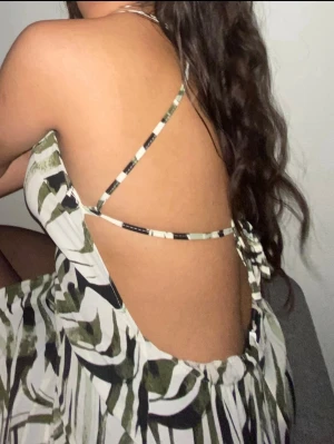 Zebraprinted mini dress  - Snygg kort klänning med zebramönster i vitt, svart och grönt. Klänningen har tunna axelband och en öppen rygg med knytning. Perfekt för dig som vill sticka ut med en trendig look.