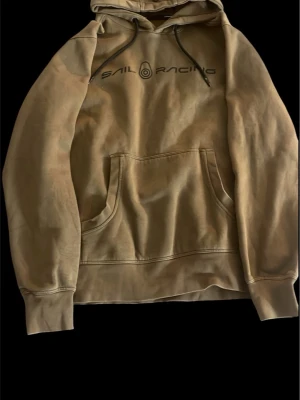 Sail racing hoodie - Hej! Säljer en Sail Racing hoodie i färgen olive grön/khaki i storlek M som har en liten skada på en av snörens metall men de är inget som förstör själva hoodien, skick 7/10 pris kan diskuteras vid snabbaffär vid frågor och funderingar är de bara och skriva!