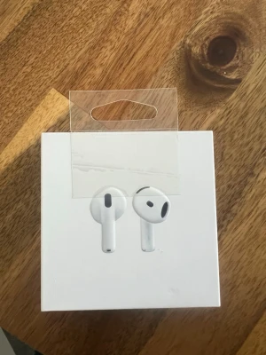 Apple AirPods 4 trådlösa hörlurar - Säljer ett par Apple AirPods 3 i vitt med stilren och kompakt design. Hörlurarna är trådlösa och levereras med ett matchande laddningsetui i plast. Perfekta för musik, samtal och gaming. Klassisk Apple-look med rundade former och minimalistisk känsla.AirPods 4. Köpt på grund av borttappade hörlurar som sedan blev återfunna därav försäljning då öppet köp inte gäller på Kjell och Company. Kvitto finns för bevisning! Inte mer än 1 månad gamla. 