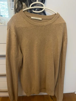 Beige stickad tröja A Day's March - Klassisk beige stickad tröja från A Day's March med rund halsringning och ribbade muddar. Tröjan är i storlek S men sitter större, lite som en overzised M. Fint skick!