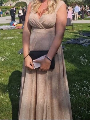 Champagnefärgad långklänning med slits - Säljer denna balklänning. Glittrig rosa/beige. Perfekt nu till balen🥰🥰