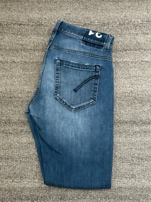 Dondup Jeans George - Snygga blå jeans från Dondup. Jeansen har raka ben och en stilren look, perfekta till en avslappnad outfit. Materialet är mjukt denim i bomull. Mycket bra skick, äkta, inga defekter. 