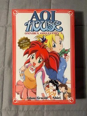 Aoi House Omnibus Collection 1 - Aoi House Omnibus Collection 1 är en mangabok av Adam Arnold och Shiei. Omslaget är färgglatt med animeinspirerade karaktärer och en hamster. Boken är på engelska och har en röd ram runt omslaget. Perfekt för dig som gillar humor och animekultur.