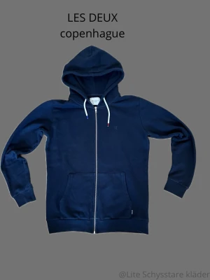 Les Deux hoodie  - Säljer en mörkblå hoodie från Les Delux. Tröjan är i utmärkt skick, inga defekter. Tröjan är i storlek S, men skulle säga att den har lite större passfrorm. Han på bilden är 183 och väger 67 kilo. Om ni har mer frågor eller funderingar är de bara att skriva:). 