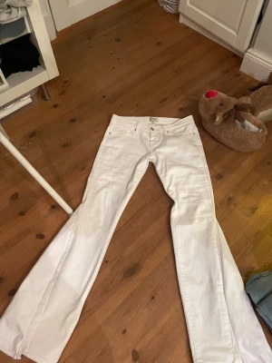 Lågmidjade vita jeans - Säljer dessa lågmidjade jeans som är utsydda till bootcut. Jeansen är i stretchigt matrial och fint skick, inga fläckar eller liknande. Midjrmått 36 cm och innerbenslängd 70 cm. Kolla gärna min profil där jag säljer fler liknande jeans💗