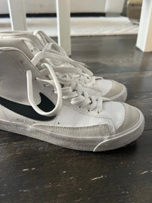 Vita Nike Blazer Mid sneakers - Nike Blazer Mid sneakers i vitt skinn med grå mockadetaljer. Endast använda ett par gånger perfekta till gym eller vardags! 🌸