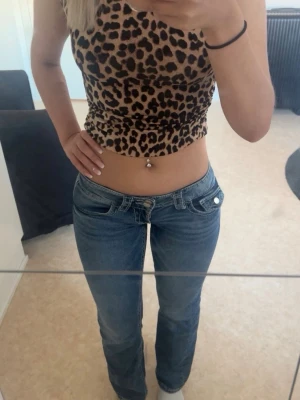 Low waist bootcut jeans  - Säljer ett par klassiska blå bootcut jeans med låg midja och fem fickor. Jeansen har en snygg tvätt och sitter tajt över höfterna för en schysst siluett. Perfekta till crop tops eller hoodies för en avslappnad look. Strl 164