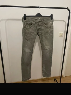 Grå slim fit jeans från G-Star RAW - Snygga grå slim fit jeans från G-Star RAW med klassisk femficksdesign och diskreta slitningar. Jeansen har låg midja och smala ben, perfekta för en avslappnad men trendig look. Tillverkade i bomull med lite stretch för extra komfort.