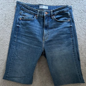 Blå raka jeans från Stradivarius - Säljer ett par klassiska blå jeans från Bershka med rak passform och hög midja. Modell: straight slim fit. Storlek 36. Når precis till hälarna, är 164cm lång. Använd endast 1-3 gånger