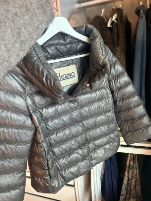 Grå dunjacka från Herno - Snygg grå dunjacka från Herno med hög krage. Perfekt för sommarkvällar, även otrolig på vintern och riktigt lätt att styla till olika outfits. Storlek 42it vilket motsvarar S. Är villig att sänka priset vid snabb affär 🥰 