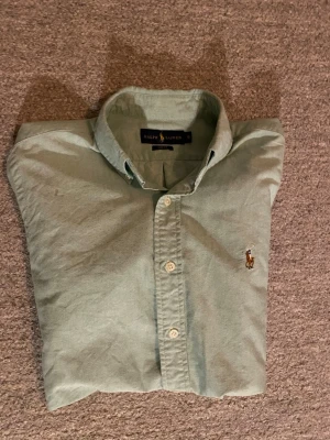 Ralph lauren skjorta - Snygg grön skjorta från Ralph Lauren i storlek S och slim fit model. Den her en mint grön färg. Inga defekter eller flaws och är använd fåtal gånger. Hör av er av intresse.