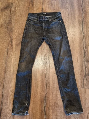 Svarta skinny jeans med blå tvätt - Snygga svarta skinny/baggy jeans från jack and Jones med blå tvättade detaljer. Klassisk femficksmodell och låg midja. Jeansen har smal passform och är tillverkade i stretchigt denim för extra komfort. Perfekta för en trendig och avslappnad stil.