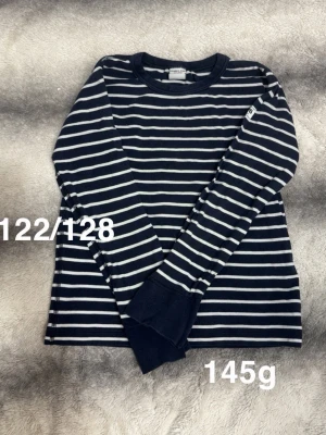 Randig långärmad tröja Polarn O. Pyret - Mörkblå långärmad tröja från Polarn O. Pyret med vita horisontella ränder. Klassisk rund halsringning. Perfekt för en avslappnad och stilren look.🌸 Fint använt skick. Storlek 122/128