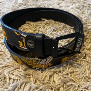 Svart bälte från Versace Jeans Couture - Snyggt svart bälte från Versace Jeans Couture, skick 9/10 inget fel. Pris kan diskuteras, funkar för män och kvinnor skriv för fler bilder 