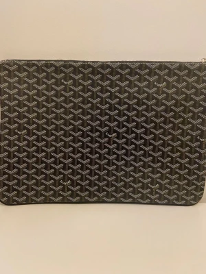 Datorväska  - Säljer en snygg och oanvänd datorväska! Mått: ca 41cm x 28cm. Väskan är i nyskick och väldigt fin. Den rymmer gott om plats och passar perfekt för laptop, surfplatta, dokument och andra småsaker. Insidan är rymlig och skyddar dina saker bra.    Fejk