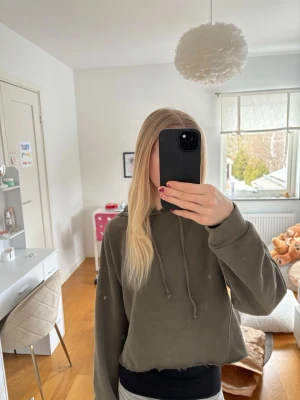 Mörkgrön cropped hoodie med huva - Säljer en mörkgrön croppad hoodie med huva. Hoodien har långa ärmar, rå kant nertill och är tillverkad i mjukt sweatshirtmaterial. Perfekt för en avslappnad och trendig look💚💚