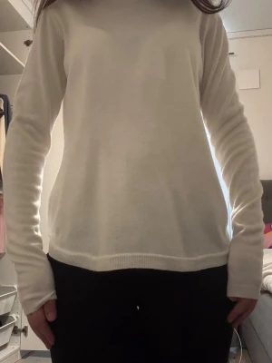 Vit finstickad tröja  - En enkel och stilren vit stickad tröja med rund hals och långa ärmar. Tröjan har en rak passform och ribbstickade muddar vid ärmslut och nederkant. Perfekt att matcha med jeans eller kjol för en clean look.