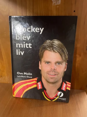 Hockey blev mitt liv av Ove Molin - Säljer boken 'Hockey blev mitt liv' av Ove Molin och Lars-Rune Ölund. Boken har hård pärm med svart omslag och färgglada detaljer. Perfekt för dig som gillar sport, hockey och personliga berättelser om livet och karriären.