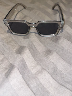 Silvriga solglasögon med metallbåge - Snygga solglasögon med silvrig metallbåge och klassisk form. Perfekt för dig som vill ha en stilren och modern look. Glasögonen har tunna bågar och passar till många olika outfits.