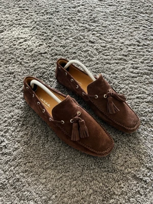 Bruna mockasiner  - Extremt snygga bruna mockasiner. Knappt använda alltså är dom nästan nyskick. Väldigt bekväma. Storlek 42
